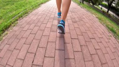 Gün batımı koşu için parkta eğitim spor ayakkabı açık çalışan yavaş hareket ters. ülke yolda arka yan görünüm.