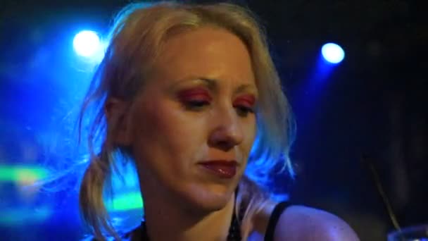 Sexy Blondýnka Pije Koktejl Tmavé Diskotéce Pod Modrozelenými Laserovými Záblesky — Stock video