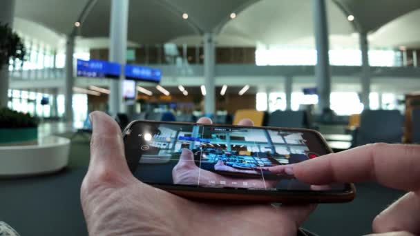 Der Hand Hält Ein Smartphone Das Die Kameraansicht Eines Flughafenwartebereichs — Stockvideo