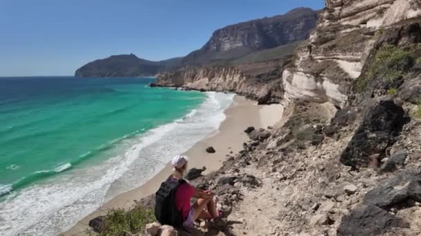 阿曼Salalah Fizayah海岸的一名女游客 一位旅行者惊奇地发现 在色拉哈海滨城市美丽的风景环绕下 白色的沙滩和碧绿的大海形成了迷人的对比 — 图库视频影像