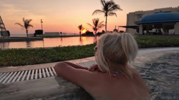 수영장 석양을 맛보는 여자의 여자는 해변에서 아름다운 지평선에 인피니티 풀에서 — 비디오