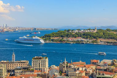 İstanbul 'daki Galata Kulesi' nin gökyüzü manzarasında, açık güneşli bir günde boğaz ve yolcu gemisi görülüyor..
