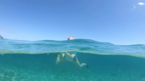 意大利爱尔巴岛上 一个戴着太阳镜的无忧无虑的女人在晴朗的天空下漂浮在费托维亚海滩清澈的蓝水中 缓慢运动中的托斯卡纳群岛海洋保护区 — 图库视频影像