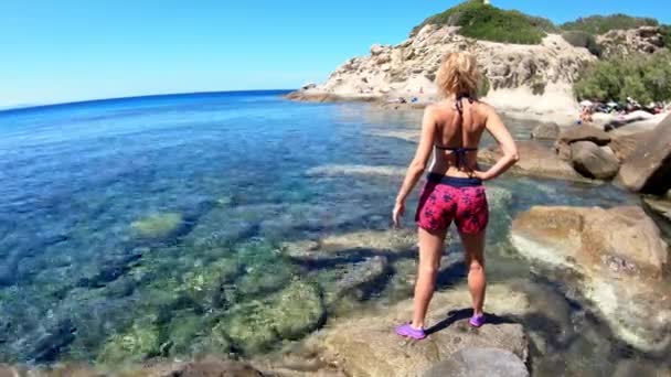 女游客站在岩石上 欣赏意大利受欢迎的海滨旅游胜地爱尔巴岛圣安德鲁海滩清澈的海水 意大利托斯卡纳群岛地中海 — 图库视频影像