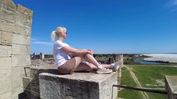游客妇女在古城墙上放松 俯瞰着法国阳光灿烂的普罗旺斯令人叹为观止的中世纪城市景观 — 图库视频影像