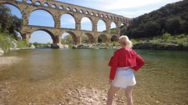 Misafir kadın, Fransa 'nın Provence kentindeki antik Roma su kemeri Pont du Gard' a hayran.