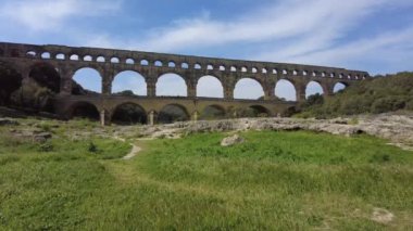 Antik Roma su kemeri, Pont du Gard, Fransa 'nın Nimes kenti yakınlarındaki pitoresk Provence' de açık mavi bir gökyüzünün altında.