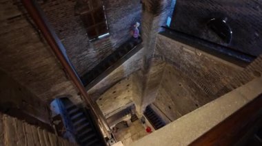 Ghirlandina çan kulesinin içindeki panoramik manzaranın merdivenlerindeki turist kadın, Modenas 'ın çarpıcı mimarisini gözler önüne seriyordu.