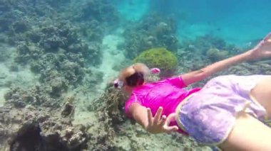 Sualtı maceracısı Ürdün, Akabe yakınlarındaki Kızıldeniz 'in kristal berrak sularında canlı sarı ateş mercanları üzerinde şnorkelle yüzer.