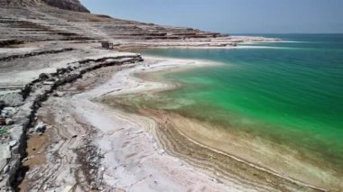 Ürdün 'deki Ürdün kıyıları boyunca Ölü Deniz' in eşsiz jeolojik katmanlarını ve sakin sularını yansıtan sakin panoramik hava görüntüsü