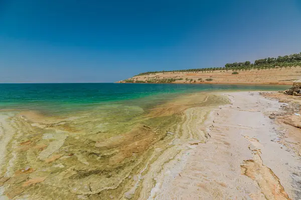 stock image Serene panoramic view capturing the unique geological layers and tranquil waters of the Dead Sea along the Jordanian coast in Jordan