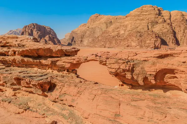 stock image Breathtaking natural rock arch, known as Little bridge stands resilient amidst the stunning red sands, and rugged mountains of the iconic Wadi Rum desert in Jordan