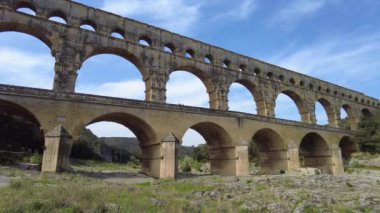 Antik Roma su kemeri, Pont du Gard, Fransa 'nın Nimes kenti yakınlarındaki pitoresk Provence' de açık mavi bir gökyüzünün altında.