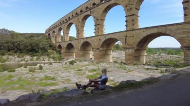 Kadın gezgin, Fransa 'nın Provence kentindeki Pont du Gard adlı UNESCO dünya mirası sahasına bakıyor..