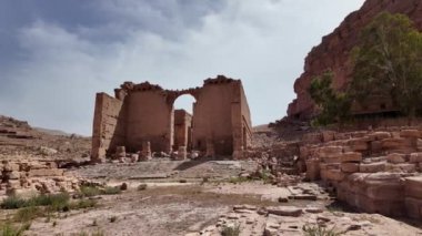 Çöken kumtaşı duvarları ve kolonları olan Dushares Tapınağı Ürdün 'ün Petra kentindeki kutsal Qasr Al Bint karakoluna açılan anıtsal geçitten geriye kalan tek şey.