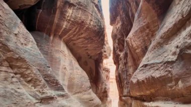 Hazine 'ye doğru yürüyen turist kadının hava görüntüsü Ürdün' ün antik Ürdün şehri Petra 'nın kumtaşı yamaçlarına oyulmuş en ayrıntılı tapınaklarından biridir.
