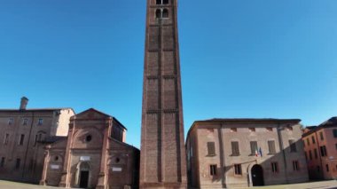 Castello 'daki Santa Maria kilisesindeki Carpi' nin şehir kulesi Piazza dei martiri 'de dimdik duruyor. Mavi gökyüzünün altında parlak tuğlaları parlıyor.
