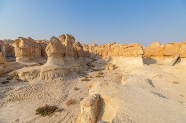 Jabal Al Qarah dağ mağaraları güneş ışığı altındaki renkli kumtaşı katmanlarını göstererek El Ahsa, Suudi Arabistan 'daki berrak mavi gökyüzü ile çarpıcı bir tezat oluşturuyor.