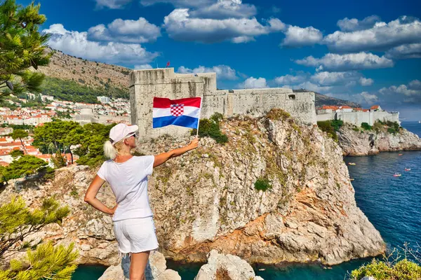 Hırvatistan 'ın Dubrovnik kalesi Lovrijenac' ta Bokar Kalesi 'nde bir kız tarafından tutulan Hırvat bayrağı. Dubrovnik UNESCO Dünya Mirası Alanı, Dalmaçya 'nın eski bir Venedik kenti olan Hırvatistan' dır..