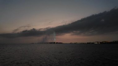 Kral Fahds Çeşmesi, dünyanın en uzun çeşmesi, gün batımında, Jeddah Rıhtımı, Suudi Arabistan 'da, dramatik bulutlu gökyüzü ve sakin denizle su püskürtür.