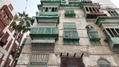 Jeddah, Suudi Arabistan - 7 Ocak 2025: Ahşap balkonları ve süslü pencereleri olan geleneksel binalar, UNESCO 'nun Dünya Mirası sitesi olan Jeddahs tarihi bölgesinde dar bir sokak hizasında.