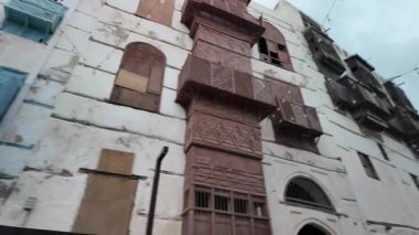 Jeddah, Suudi Arabistan - 7 Ocak 2025: Ahşap balkonlu geleneksel binalar ve Suudi Arabistan 'ın tarihi Jeddah ilçesi Al-Balad' da bir minare standı, UNESCO Dünya Mirası sahası