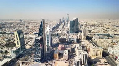Riyad, Suudi Arabistan 'ın panoramik manzarası, engin şehir genişliğini, hareketli caddeleri ve aydınlık, güneşli gökyüzü altındaki modern mimariyi gözler önüne seriyor.