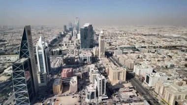 Suudi Arabistan 'ın başkenti Riyad' ın panoramik manzarası engin şehir genişliğini, modern mimarisini ve dağınık mavi bulutların altında hareketli caddeleri gözler önüne seriyor.