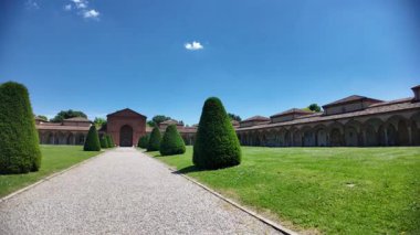 15. yüzyıl Ferrara Charterhouse 'u, San Cristoforo kilisesi ile yemyeşil çimlere karşı kurulmuş. Asılan lambalar, mezarlar ve heykellerin yer aldığı antik mezarlık manastırı..