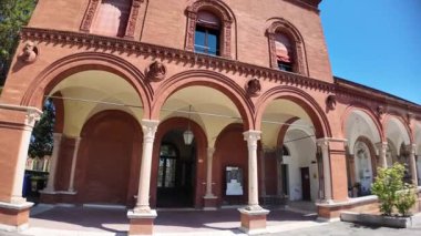 Ferrara, İtalya - 17 Mayıs 2025: Ferrara, İtalya Charterhouse 'un büyüleyici mimari güzelliğini deneyimleyin, parlak mavi gökyüzü altında zarif kemerlerini ve huzurlu bahçe manzaralarını sergiliyor