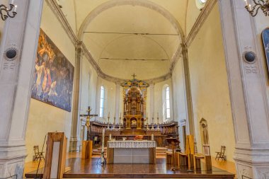 Ferrara, İtalya - 17 Mayıs 2025: İtalya 'nın Ferrara kentindeki San Cristoforo Kilisesi' nin iç manzarası, bir haç, tören için hazırlanmış sunak ve ahşap zemin