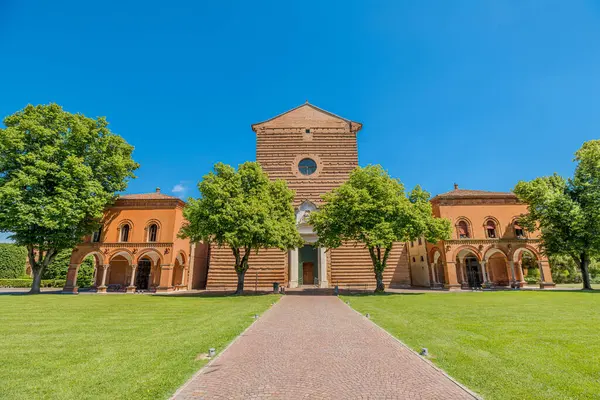 İtalya 'nın Ferrara kentindeki Aziz Christopher Kilisesi, eşsiz bir Cotto tuğla cephesine sahip, yemyeşil çimenler ve ağaçlar arasında berrak mavi bir gökyüzü altında görkemli bir şekilde yükselir.