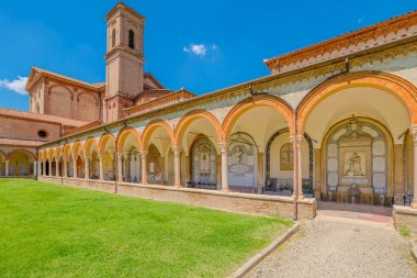 Ferrara, İtalya - 17 Mayıs 2025: Açık mavi gökyüzü altında yemyeşil çimenler arasında bir kilise, çan kulesi ve manastır bulunan Ferrara Çartır evini geniş açı görüşü