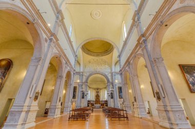 Ferrara, İtalya - 17 Mayıs 2025: Güneş ışığı, Ferrara 'daki Saint Christopher Kilisesi' nin parlak zeminini aydınlatarak ahşap bankları ve büyük sütunları aydınlatıyor.