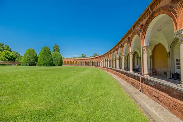 İtalya 'nın Ferrara şehrinde, Ferrara şehrinde yemyeşil bir çimenliğe karşı kurulmuş, 15. yüzyıl Ferrara Charterhouse' unda asılı lambalar, mezarlar ve heykeller bulunan antik mezarlık manastırı.