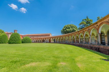 Ferrara Charterhouse of Ferrara 'daki Aziz Christopher Kilisesi, İtalya' nın Ferrara şehrinde berrak mavi bir gökyüzünün altında yüksek bir çan kulesinin yanında zarif kemer ve sütunlara sahip çarpıcı bir Rönesans verandasına sahiptir.