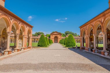 15. yüzyıl Ferrara Charterhouse 'u, San Cristoforo kilisesi ile yemyeşil çimlere karşı kurulmuş. İtalya 'nın Ferrara şehrinde asılı lambalar, mezarlar ve heykellerin yer aldığı antik mezarlık manastırı.
