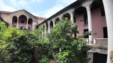 Gürcistan 'daki terk edilmiş Sanatoryum Gelati' nin bahçesini çürüyen kolonlar ve unutulmuş bir lüks geçmişi çağrıştıran bir cephe ile dolduran yemyeşil bitki örtüsü.