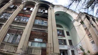 Gürcistan 'daki terk edilmiş Sanatoryum Gelati' nin dış cephesi, kapalı balkonların artık yerlerinden edilen aileler için geçici evler olarak kullanıldığı bir kayıp ve hayatta kalma mirasına işaret ediyor..