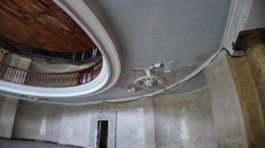 Güneş ışığı, balkonlu dairesel bir odanın çürüyen ahşap tavanındaki deliklerden akıyor ve sütunlar Georgia 'daki terk edilmiş Sanatoryum Metalurjistinin harap halini vurguluyor.