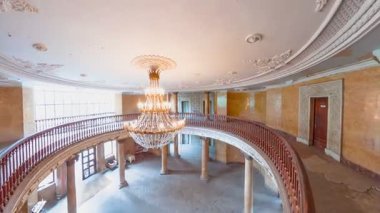 Sanatoryum Metalurjisti, Tsqaltubo, Georgia 'da kristal bir avize, ahşap bir bale salonu ve köşe yazılarıyla çürüyen bir balo salonunun geniş açılı görüntüsü, geçmişteki bir dönemin ihtişamını ve düşüşünü gözler önüne seriyor.