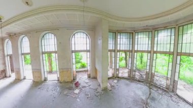 Terk edilmiş bir oda ağacının panoramik manzarası. Kemerli ve dikdörtgen pencereli. Çürüyen Sanatoryum Metalürjistinde yeşil bir manzara var.