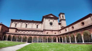 Güzel bir manastır ve yemyeşil çimlere sahip Ferrara Çartır Kilisesi güneşli bir günde açık mavi gökyüzünün altında önemli bir anıt olarak duruyor.