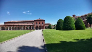 Ferrara şehrinin anıtsal mezarlığının ortasındaki San Cristoforo Kilisesi: Ferrara Charterhouse. İtalya 'da yeşil bir çimenliği çevreleyen kemer ve kollara sahip kıvrımlı bir portico bulunur..