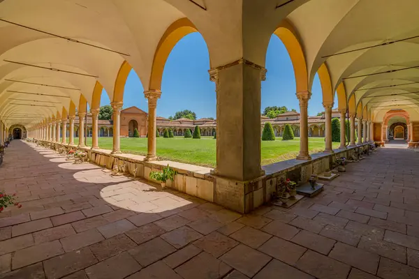 Ferrara, İtalya - 17 Mayıs 2025: Ferrara manastırının geniş açılı manzarası, sütunlar, kemerler, yeşil bir çimen ve mavi gökyüzü