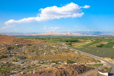 Ermenistan 'daki Khor Virap manastırı mezarlığından panoramik manzara, arka planda parlak mavi bir gökyüzü altında görkemli tarım manzaraları sergiliyor.