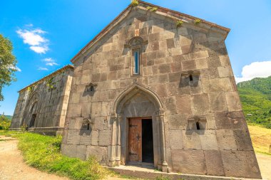 Ermenistan 'daki bir UNESCO Dünya Mirası sahası olan Haghpat Manastırı, Ermenistan' daki dingin bir dağ zeminine ve canlı mavi gökyüzüne karşı karmaşık taş işçiliğiyle ortaçağ Ermeni mimarisi sergiliyor.