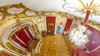 Transilvanya, Romanya - 25 Ağustos 2025: Peles Kalesi iç görünümü zengin altın süslemeler, kırmızı duvarlar, desenli halı ve Romanya 'nın Sinaia kentinde avizeler