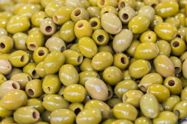 Green pitted olives closeup, background of green olives, street food market. Selective focus. High quality photo