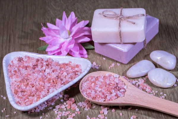 Composition spa, beauty and wellness treatment, background with Himalayan salt, natural soap and massage stones on a wooden background. High quality photo
